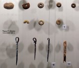 Два верхних ряда: пряслица (керамика, полива). Три предмета слева: булавки для крепления кудели (железо). Справа: фрагмент инструмента для сучения ниток (кость) Два верхних ряда: пряслица (керамика, полива). Три предмета слева: булавки для крепления кудели (железо). Справа: фрагмент инструмента для сучения ниток (кость)